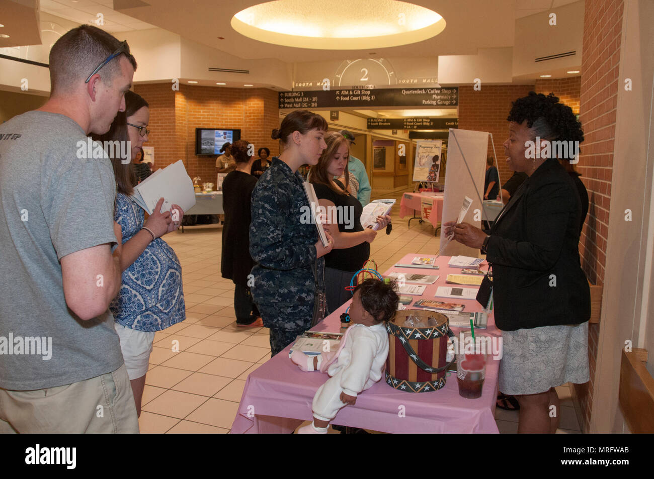 170609-N-GM597-009 Portsmouth, Va. (June 9, 2017) Racquel Pitts, a new parent support home visitor with the Fleet and Family Support Center, right, explains the programs available through FFSC for pregnant beneficiaries and new parents during the Pregnancy Fair at Naval Medical Center Portsmouth. The Women’s Health Clinic sponsored the fair that offered information on a variety of pregnancy-related topics, including nutrition, exercise, fetal development, birthing positions and lactation. (U.S. Navy photo by Rebecca A. Perron/Released) Stock Photo