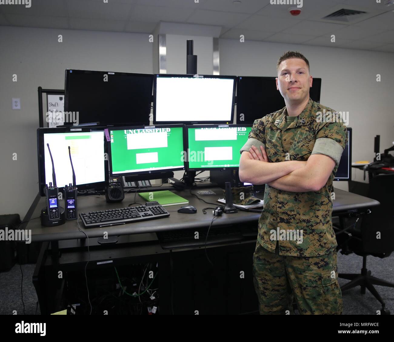 Maj. Mark Simmons, systems engineer for Consolidated Emergency Response System, stands in front of a newly-installed CERS emergency dispatcher workstation aboard Marine Corps Base Quantico, Va.  CERS aggregates multiple capabilities—Enhanced 911, Computer-Aided Dispatch, and fire station alerting—into a single workstation, giving emergency dispatchers the ability to quickly dispatch the appropriate assets where necessary. CERS increases the effectiveness of emergency response operations aboard Marine Corps installations worldwide. (U.S. Marine Corps photo by Ashley Calingo) Stock Photo