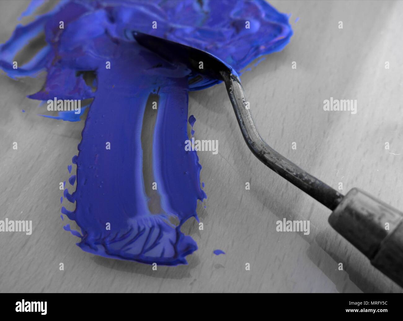 Spatula used to mix blue acrylic paint. Concept painting, being
