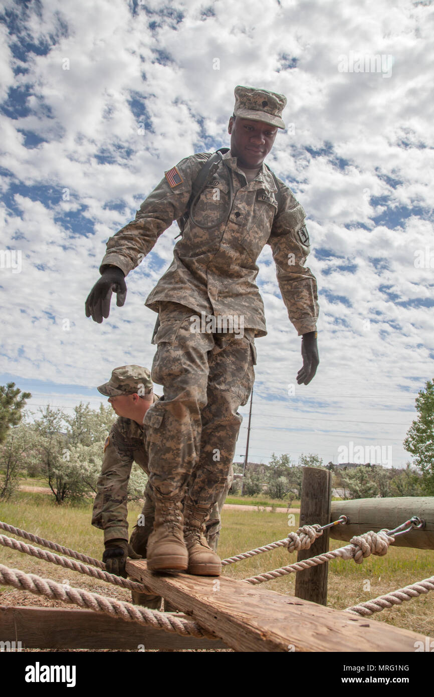 U.S. Army Spc. Jason Reed with the 1138th Transportation Company, Missouri Army National Guard, walk across a rope bridge obstacle during the Leadership Reaction Course in support of the Golden Coyote exercise at West Camp Rapid, S.D., June 13, 2017. The Golden Coyote exercise is a three-phase, scenario-driven exercise conducted in the Black Hills of South Dakota and Wyoming, which enables commanders to focus on mission essential task requirements, warrior tasks and battle drills. (U.S. Army photo by Spc. Kevin Kim) Stock Photo