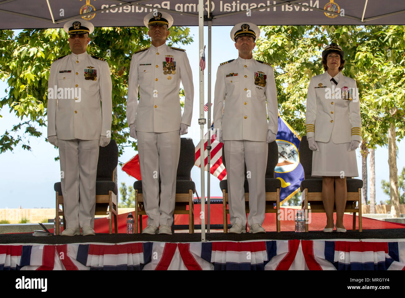 US. Naval officers honor the colors during a Change of Command Ceremony for Naval Hospital Camp Pendleton on Camp Pendleton, Calif., June 14, 2017. Capt. Frank Pearson relieved Capt. Lisa Mulligan as commanding officer during the ceremony. (U.S. Marine Corps photo by Cpl. Brandon Martinez) Stock Photo