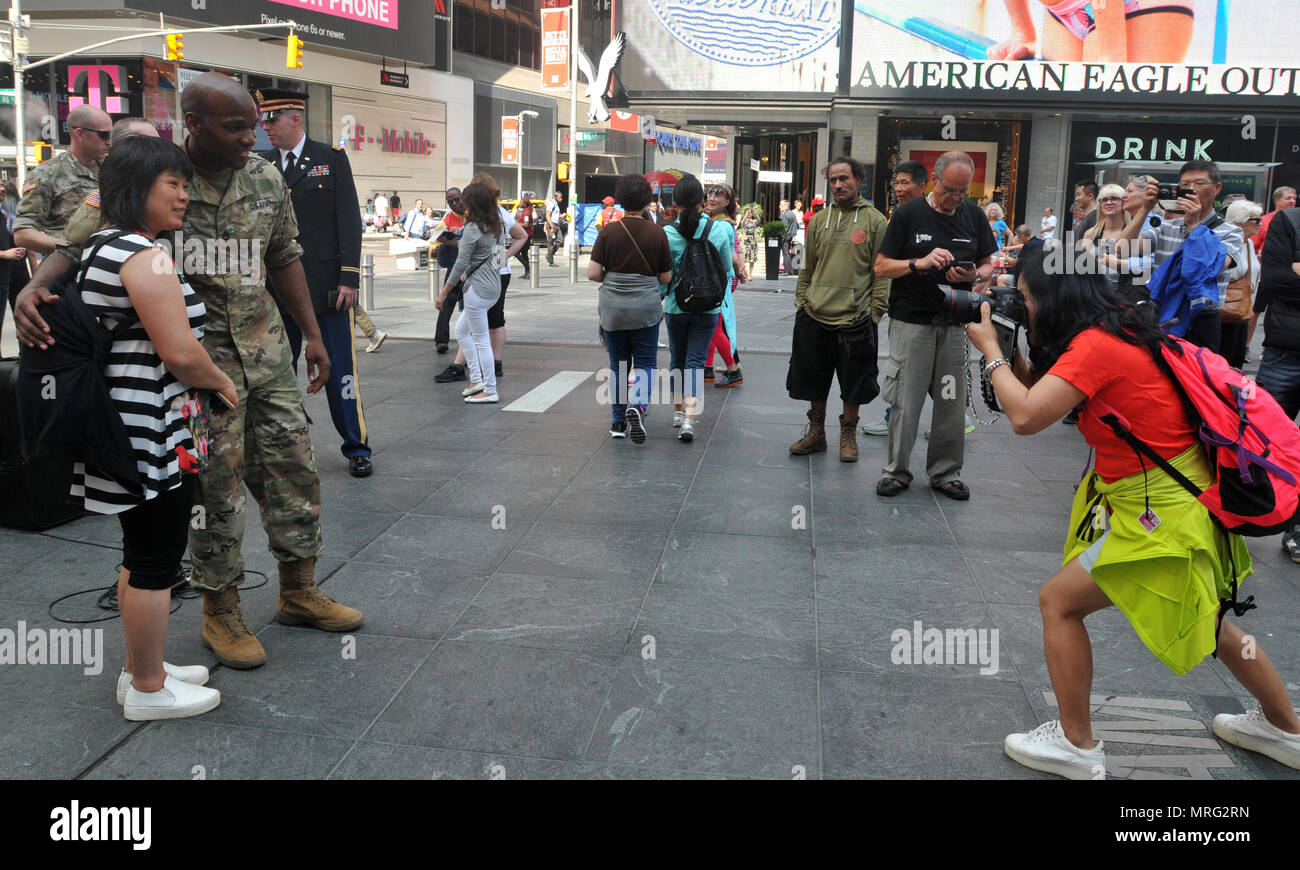 Staff Sgt. Jeremy Gaynor, vocalist with the U.S. Army West Point Benny Havens Band, poses for photos in New York City's Times Square for the Army's 242nd Birthday. Members of the Benny Havens Band did a parks and subways tour throughout the city by playing six mini-concerts in various locations to highlight the Army's Birthday. (U.S. Army photo by Staff Sgt. Alejandro Canizales (released). Stock Photo