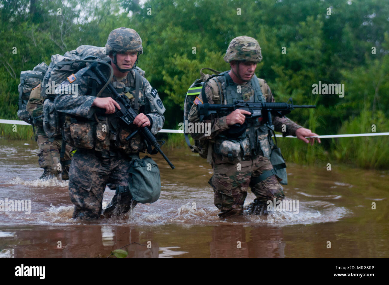 Sgt. Benjamin Morris accompanies another Warrior crossing water during a 10-kelometer foot march at the 2017 U.S. Army Reserve Best Warrior Competition at Fort Bragg; N.C. June 13. This year's Best Warrior Competition will determine the top noncommissioned officer and junior enlisted Soldier who will represent the U.S. Army Reserve in the Department of the Army Best Warrior Competition later this year at Fort A.P. Hill; Va. (U.S. Army Reserve photo by Trenton Fouche) (Released) Stock Photo