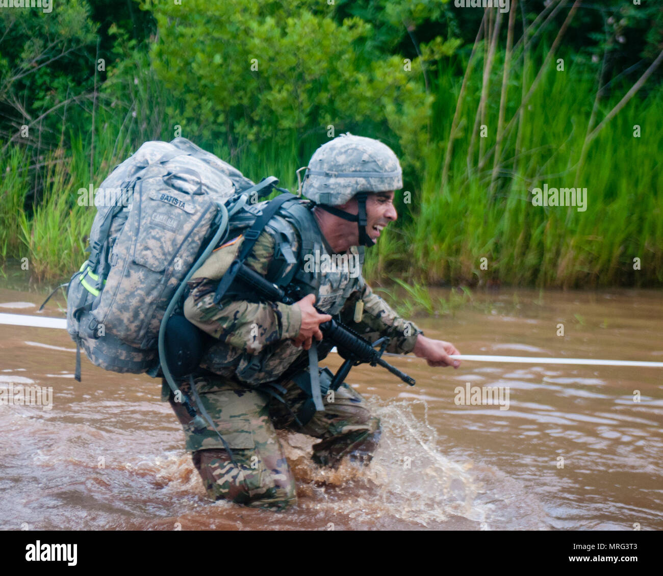 Sgt. Batista a chemical, biological, radiological and nuclear specialist representing the, 412th Theater Engineer Command crosses water during a 10-kilometer foot march at the 2017 U.S. Army Reserve Best Warrior Competition at Fort Bragg, N.C. June 13. This year's Best Warrior Competition will determine the top noncommissioned officer and junior enlisted Soldier who will represent the U.S. Army Reserve in the Department of the Army Best Warrior Competition later this year at Fort A.P. Hill, Va. (U.S. Army Reserve photo by Trenton Fouche) (Released) Stock Photo