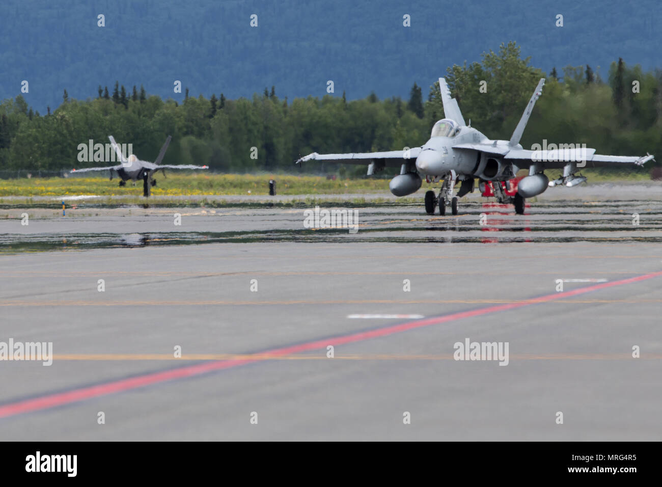 A U.S. Marine Corps F/A-18C Hornet with Marine Fighter Attack Squadron 251 taxis down a flightline during the joint training exercise Red Flag-Alaska 17-2 on Joint Base Elmendorf-Richardson, Alaska, June 13, 2017. Red Flag-Alaska provides an optimal training environment in the Indo-Asian Pacific region and focuses on improving ground, space, and cyberspace combat readiness and interoperability for U.S. and international forces. (U.S. Marine Corps photo by Lance Cpl. Koby I. Saunders) Stock Photo