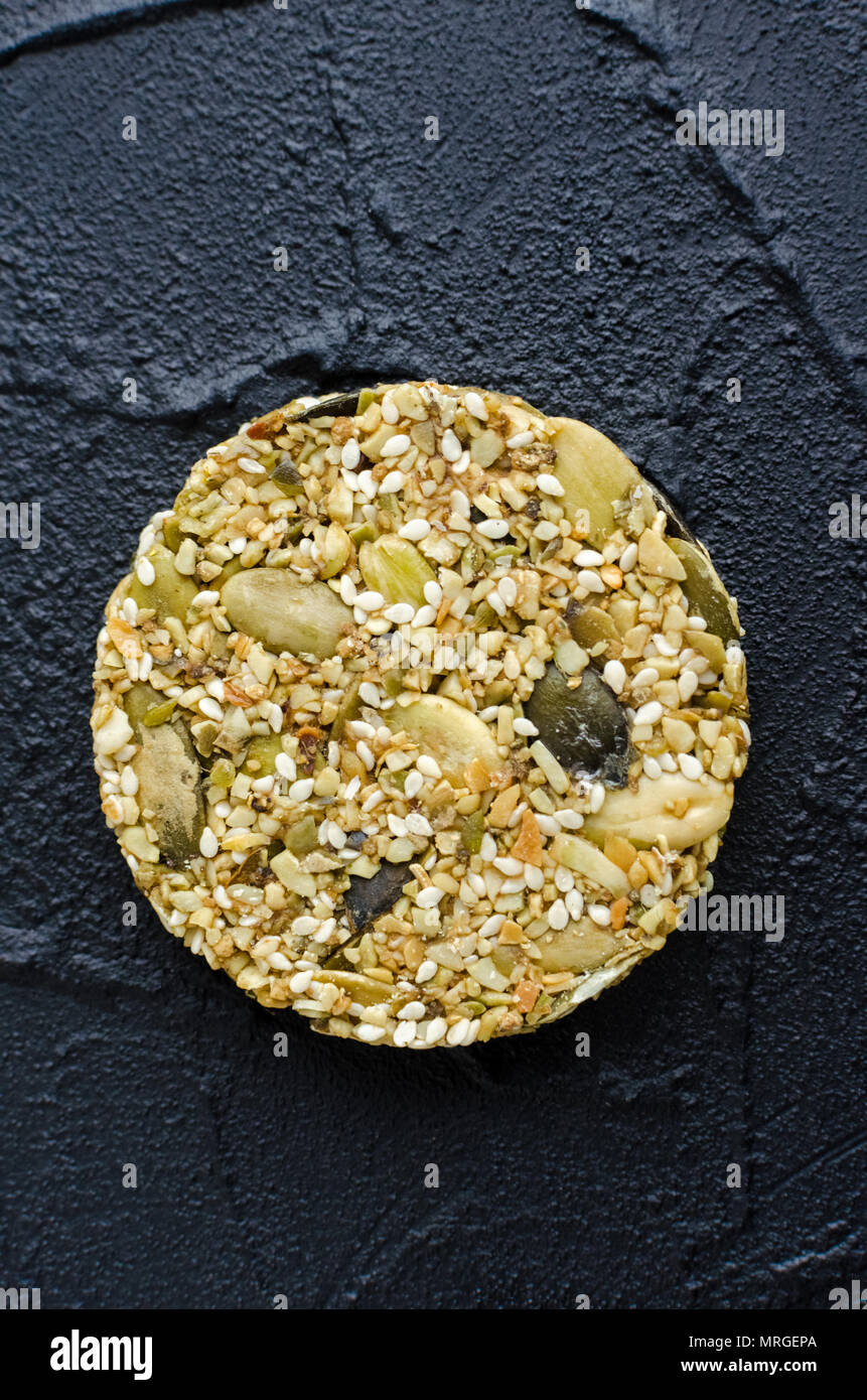 Homemade cereal snacks. Fitness dietary food. One kozinaki with sesame and pumpkin seeds with honey banana additives at the shale plate. Vegiterian he Stock Photo