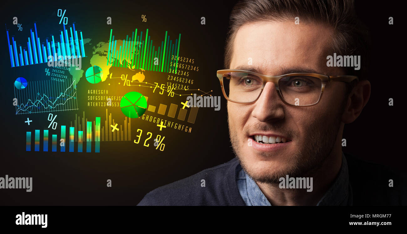 Portrait of a young businessman with colorful charts and graphs next to ...