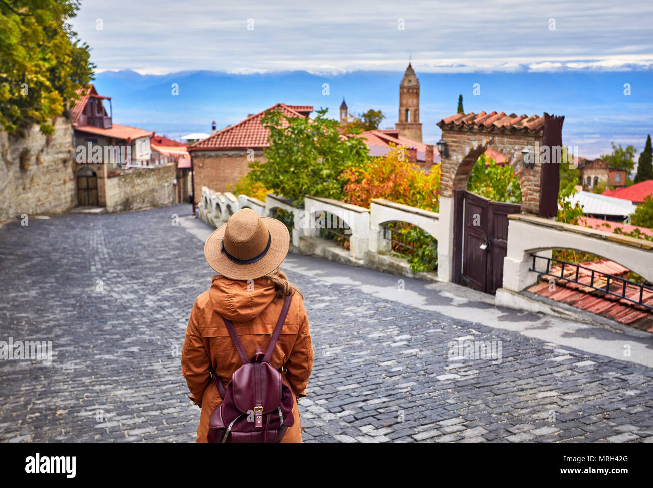 Tourist woman in Hat with backpack at the street of Signagi town in Georgia Stock Photo