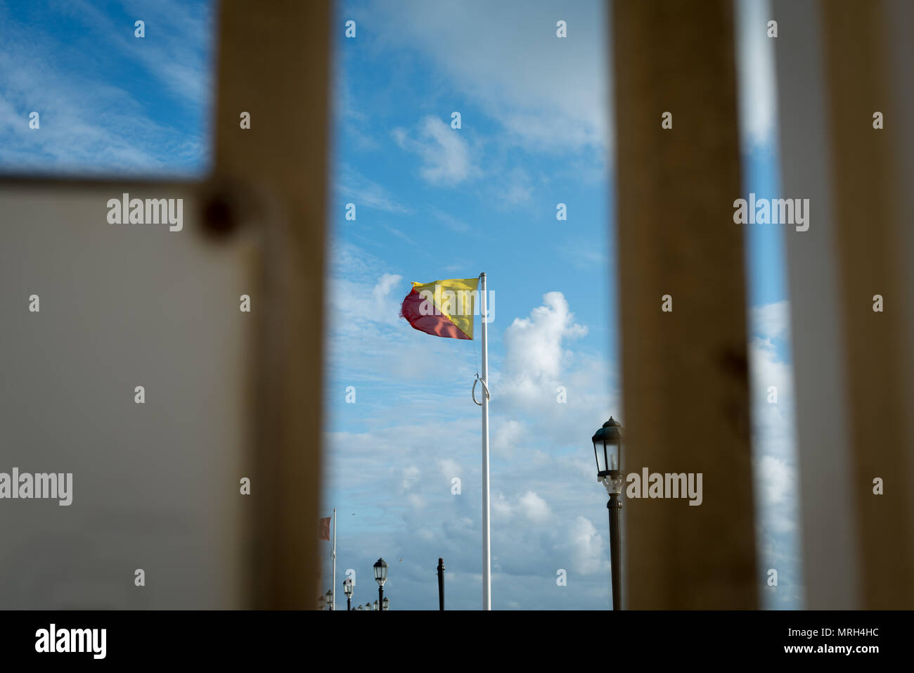 A safety flag fluttering in the wind on Worthing Pier, Worthing, West Sussex, England, UK. Stock Photo
