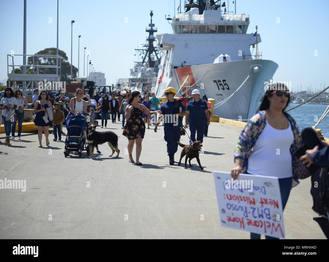 Crewmembers assigned to the Coast Guard Cutter Waesche (WMSL-751) and their  families walk on the pier at Coast Guard Island upon the cutter's return to  homeport in Alameda, California, June 19, 2017.