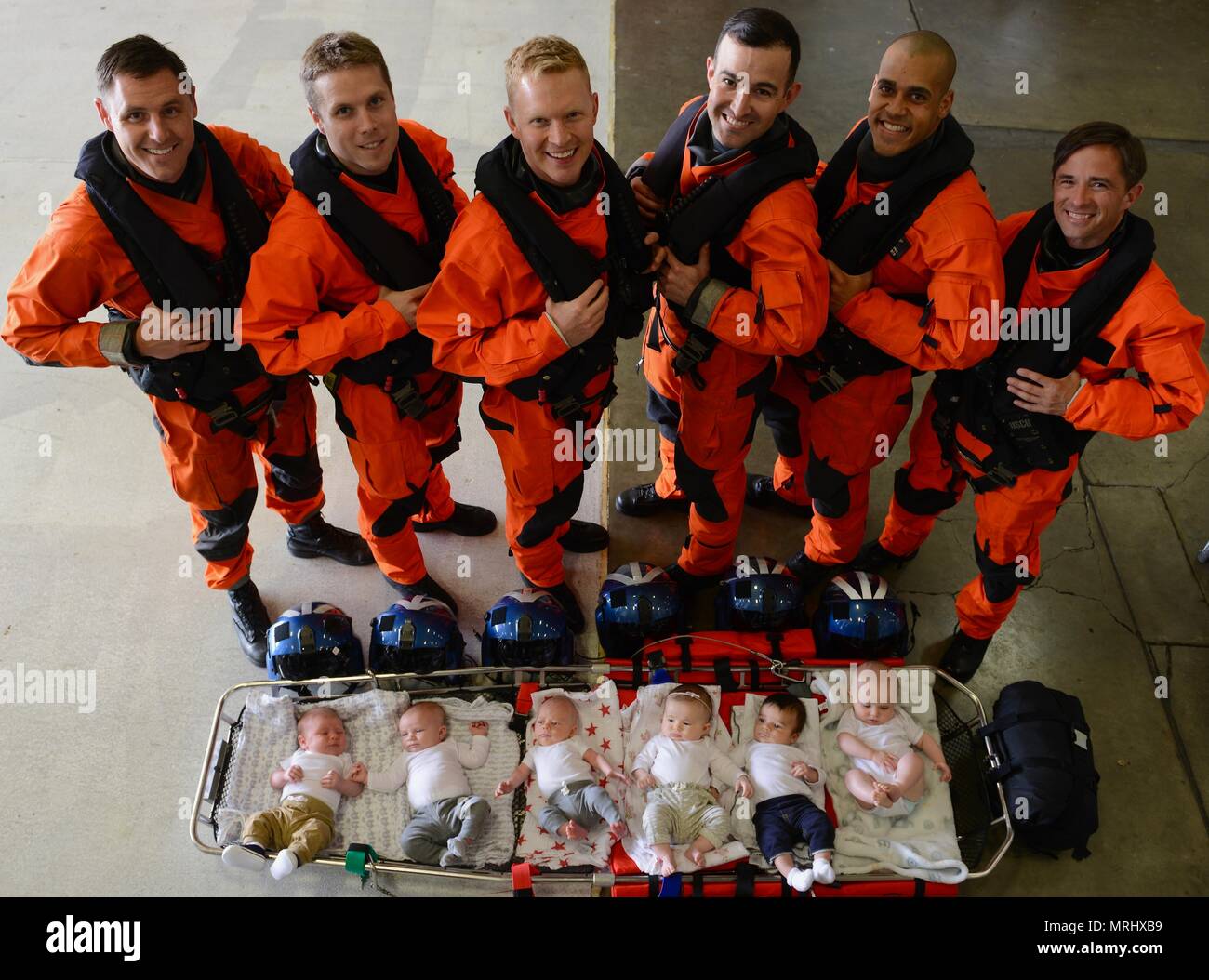 Coast Guard Sector Columbia River MH-60 Jayhawk helicopter pilots Lt. Patrick Wright, Ensign Dave Strojny, Lt. Cmdr. James Cooley, Lt. j.g. Jason Weeks, Lt. Kyle Murphy and Lt. Jonathan Ralston stand over their babies in the Sector Columbia River hangar in Warrrenton, Ore., June 13, 2017.    Each of the pilots has welcomed a new baby into their family within the last 5 months.    U.S. Coast Guard photo by Petty Officer 1st Class Levi Read. Stock Photo