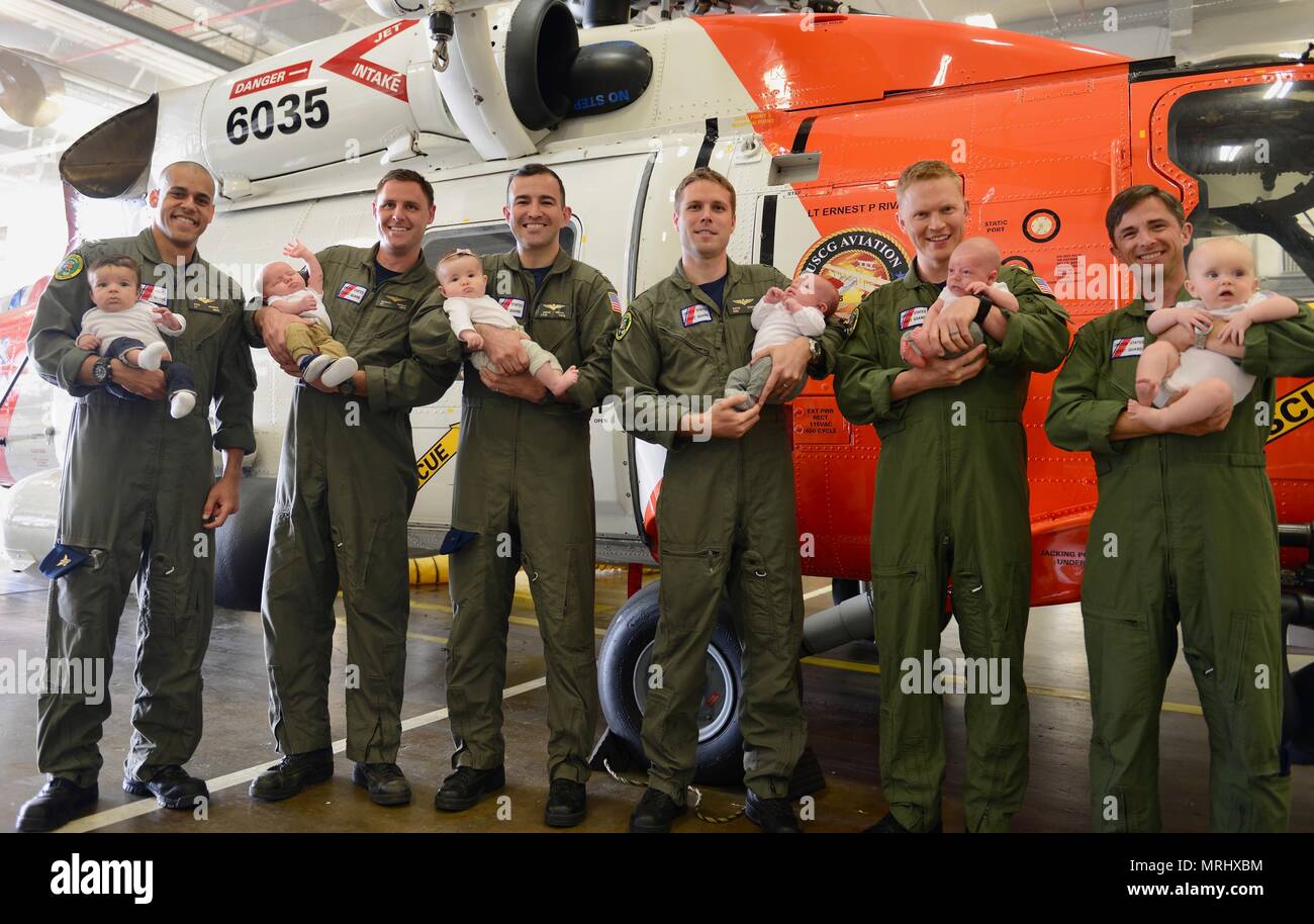 Coast Guard Sector Columbia River MH-60 Jayhawk helicopter pilots Lt. Kyle Murphy, Lt. Patrick Wright, Lt. j.g. Jason Weeks, Ensign Dave Strojny, Lt. Cmdr. James Cooley and Lt. Jonathan Ralston hold their new babies at the base hangar in Warrenton, Ore., June 13, 2017.    Six babies have joined the Coast Guard aviation family within the last 5 months.    U.S. Coast Guard photo by Petty Officer 1st Class Levi Read. Stock Photo