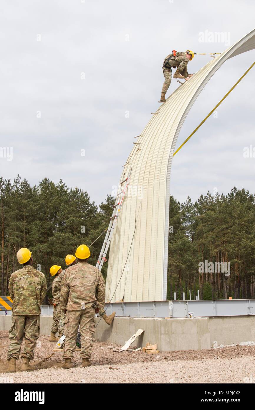 A Soldier From The 902nd Engineer Company 15th Engineer Battalion Scales The Side Of An In Process K Span Building Being Built Alongside Service Members From The United States Air Force And The U S A Soldier From The 902nd Engineer Company 15th Engineer Battalion Scales The Side Of An In Process K Span Building Being Built Alongside Service Members From The United States Air Force And The U S