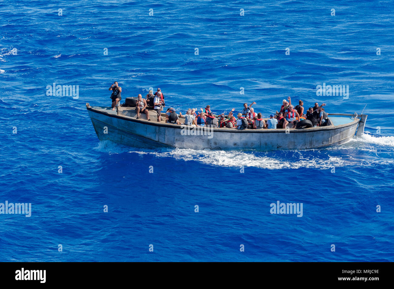 Pitcairn Island, Pacific Ocean-- March 27, 2018.  Natives of Pitcairn island wave to as they set sail to return home after visiting a nearby cruise sh Stock Photo