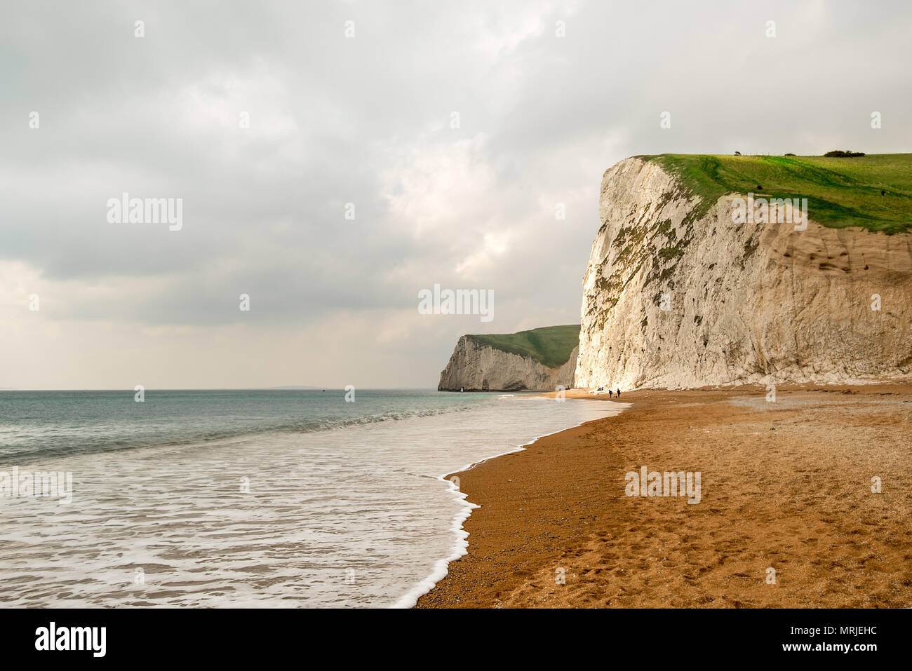 A sun beam lights up some of the shear White cliffs along Dorsets Jurassic Coast with the South West Coatal Path running along the top of them. Lulwor Stock Photo