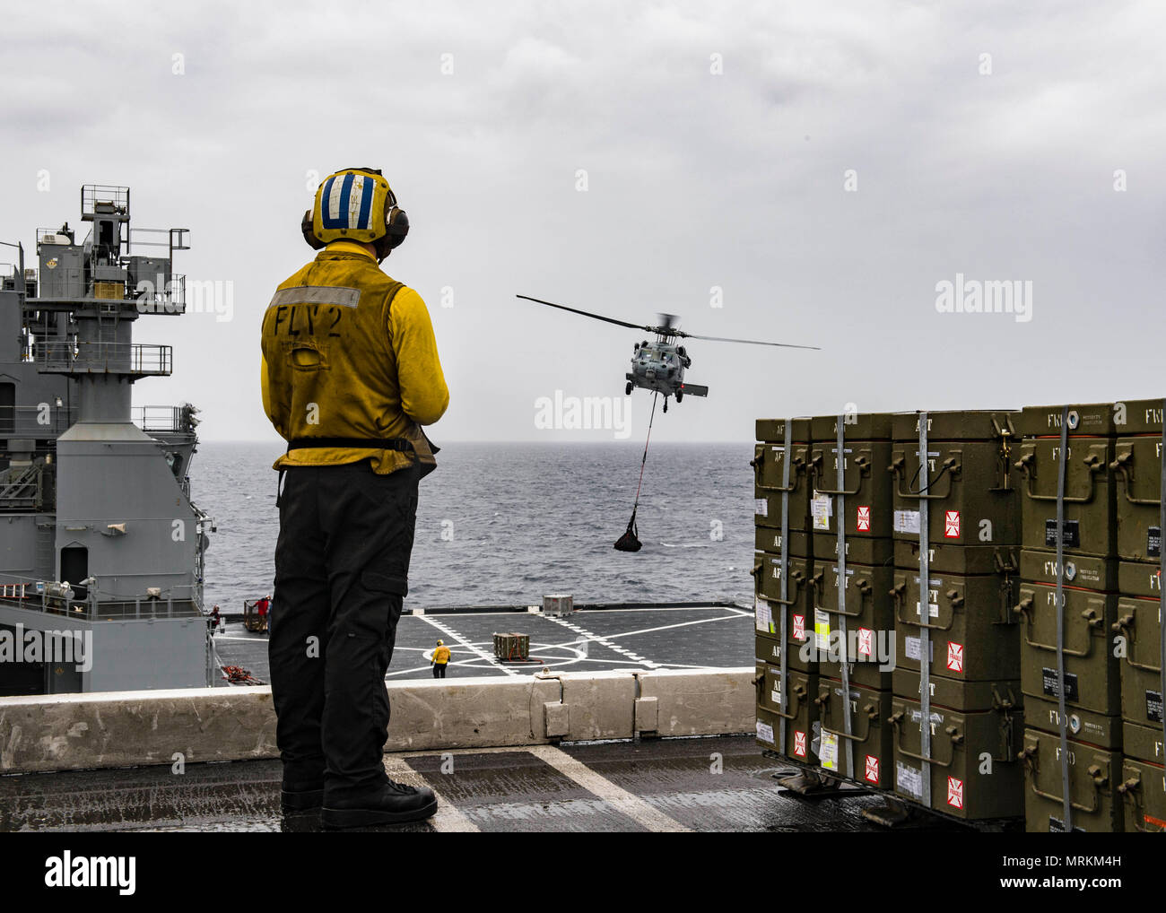 170621-N-TJ319-271   ATLANTIC OCEAN (June 21, 2017) Aviation Boatswain’s Mate (Handling) Airman John Renckens, from Selma, Ore., observes a MH-60S Sea Hawk assigned to the Dusty Dogs of Helicopter Sea Combat Squadron (HSC) 7 from the flight deck of the aircraft carrier USS Dwight D. Eisenhower (CVN 69) during an ammunition offload with the Military Sea Lift Command dry cargo and ammunition ship USNS Medgar Evers (T-AKE 13). Ike is underway during the sustainment phase of the Optimized Fleet Response Plan (OFRP). (U.S. Navy photo by Mass Communication Specialist Seaman Jessica L. Dowell) Stock Photo