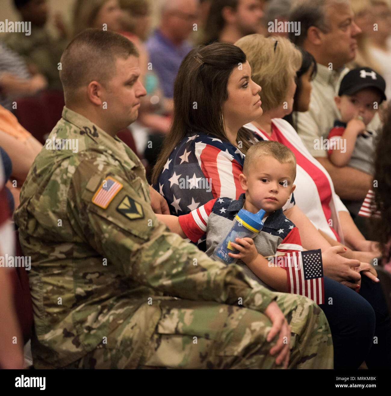 ROBINSON MANEUVER TRAINING CENTER, N. Little Rock, Ark.:— Staff Sgt. Byron Doughty, a member of the Arkansas National Guard's 39th Infantry Brigade Combat Team, and his son Byron listen to a speaker during a sendoff ceremony for the unit at Robinson Maneuver Training Center in North Little Rock on Thursday, June 22, 2107. Doughty and other Soldiers from the 39th IBCT are joining other members of their unit already deployed on the year-long mission to support the NATO peacekeeping forces in Kosovo and will be serving in the Balkan cities of Pristina and Sarajevo. (U.S. Army National Guard Phot Stock Photo
