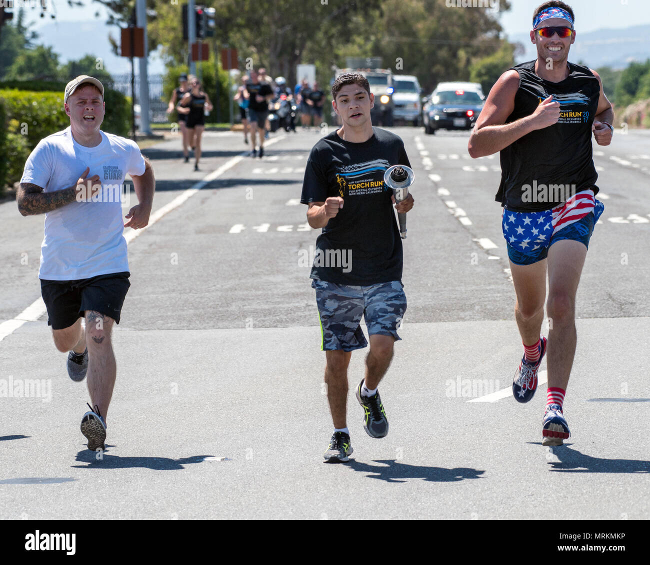 Eric Silva, a track and field athlete competing in the Special Olympics,  and police officers from the Fairfield Police Department deliver “The Flame  of Hope” Special Olympics Torch to Travis Air Force