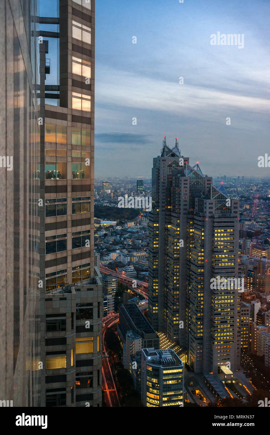 Tourists watch Shinjuku skyline at sunset with Park Hyatt Hotel skyscraper from Tokyo Metropolitan Government Building observatory, knows as Tocho, bu Stock Photo