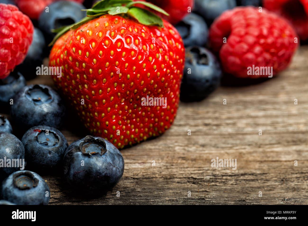 Summer strawberry, raspberry, blueberries on wooden table background. Healthy eating Stock Photo