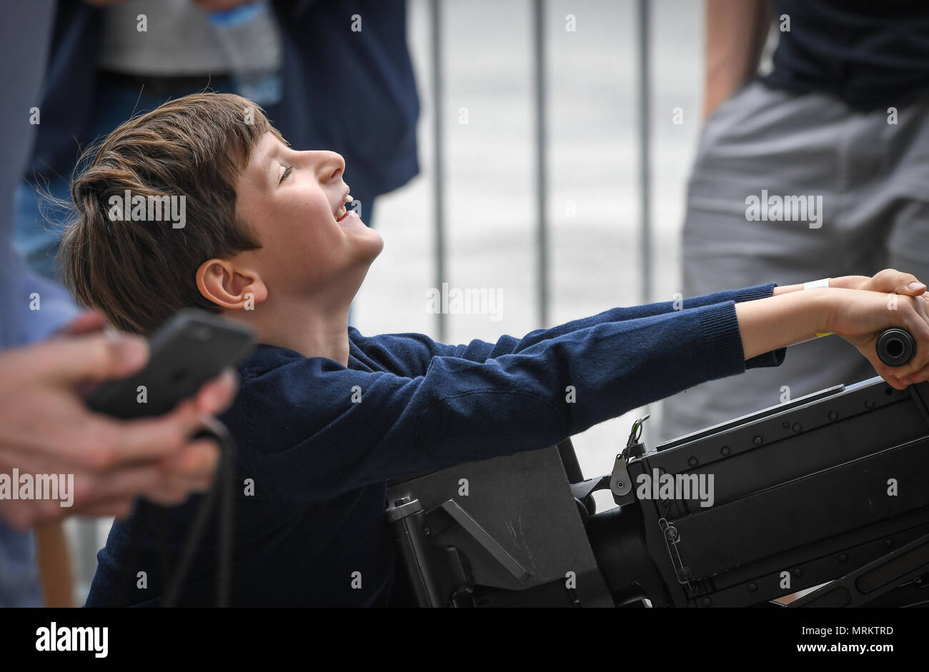 A child struggles to rack a machine gun attached to a CV-22 Osprey from Royal Air Force Mildenhall, England, at Le Bourget Airport, France, during the Paris Air Show, June 23, 2017. The Paris Air Show offers the U.S. a unique opportunity to showcase their leadership in aerospace technology to an international audience. By participating, the U.S. hopes to promote standardization and interoperability of equipment with their NATO allies and international partners. This year marks the 52nd Paris Air Show and the event features more than 100 aircraft from around the world. (U.S. Air Force photo/ Te Stock Photo