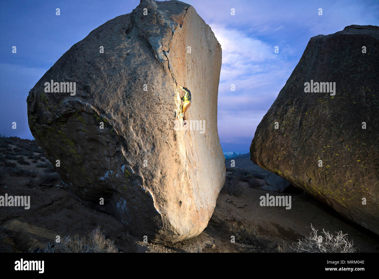 free- solo climbing up a high boulder Stock Photo