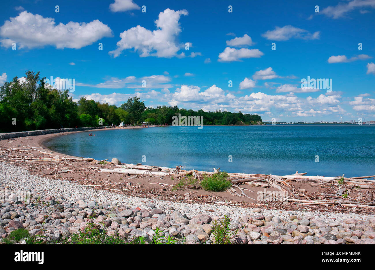 Beautiful sunny day with people on beach in blue water under blue sky and white clouds in Rouge National  Urban Park, Toronto, Ontario, Canada Stock Photo