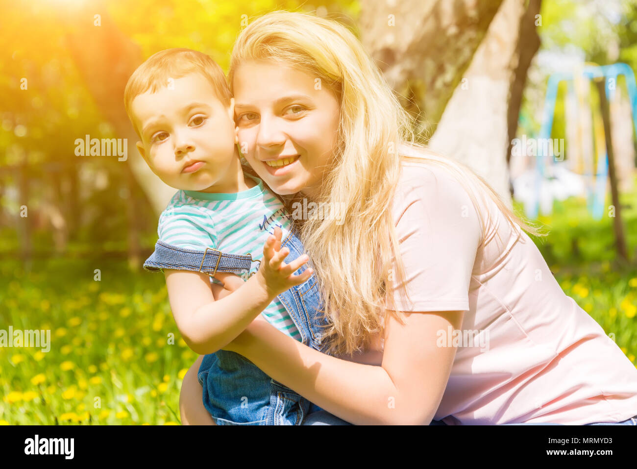 mother and child in nature in the Park, resting on the green grass in ...