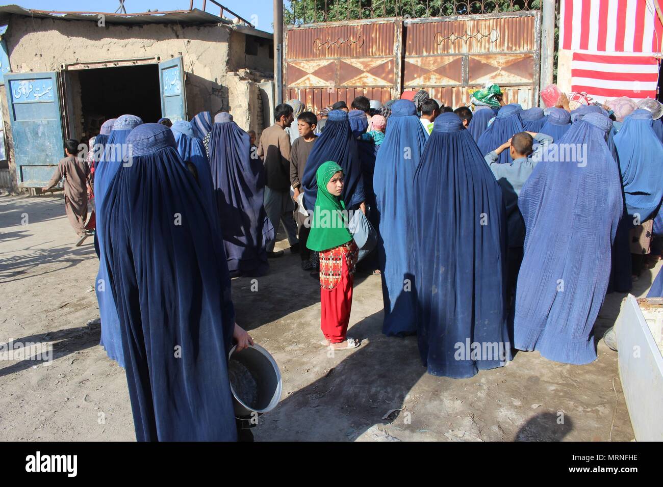 Mazar I Sharif. 27th May, 2018. Afghan women wait to receive food during the holy month of Ramadan at a mosque in Mazar-i-Sharif, capital of Balkh province, Afghanistan, May 26, 2018. According to Islamic tradition, most rich people distribute food and money to poor people during the holy month of Ramadan as a charity. Credit: Yaqoub Azorda)(srb/Xinhua/Alamy Live News Stock Photo