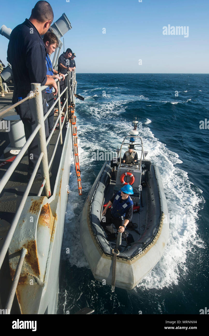 ARABIAN GULF (June 20, 2017) A rigid-hull inflatable boat from the coastal patrol ship USS Firebolt (PC 10) pulls alongside the guided-missile cruiser USS Vella Gulf (CG 72)  for a personnel transfer during Exercise Spartan Kopis 17, June 20.  Exercise Spartan Kopis is a Task Force (TF) 55-led exercise between the U.S. Navy and U.S. Coast Guard in order to increase tactical proficiency, broaden levels of cooperation, enhance mutual capability and support long-term security and stability in the region. Vella Gulf is deployed to the U.S. 5th Fleet area of operations to reassure allies and partne Stock Photo