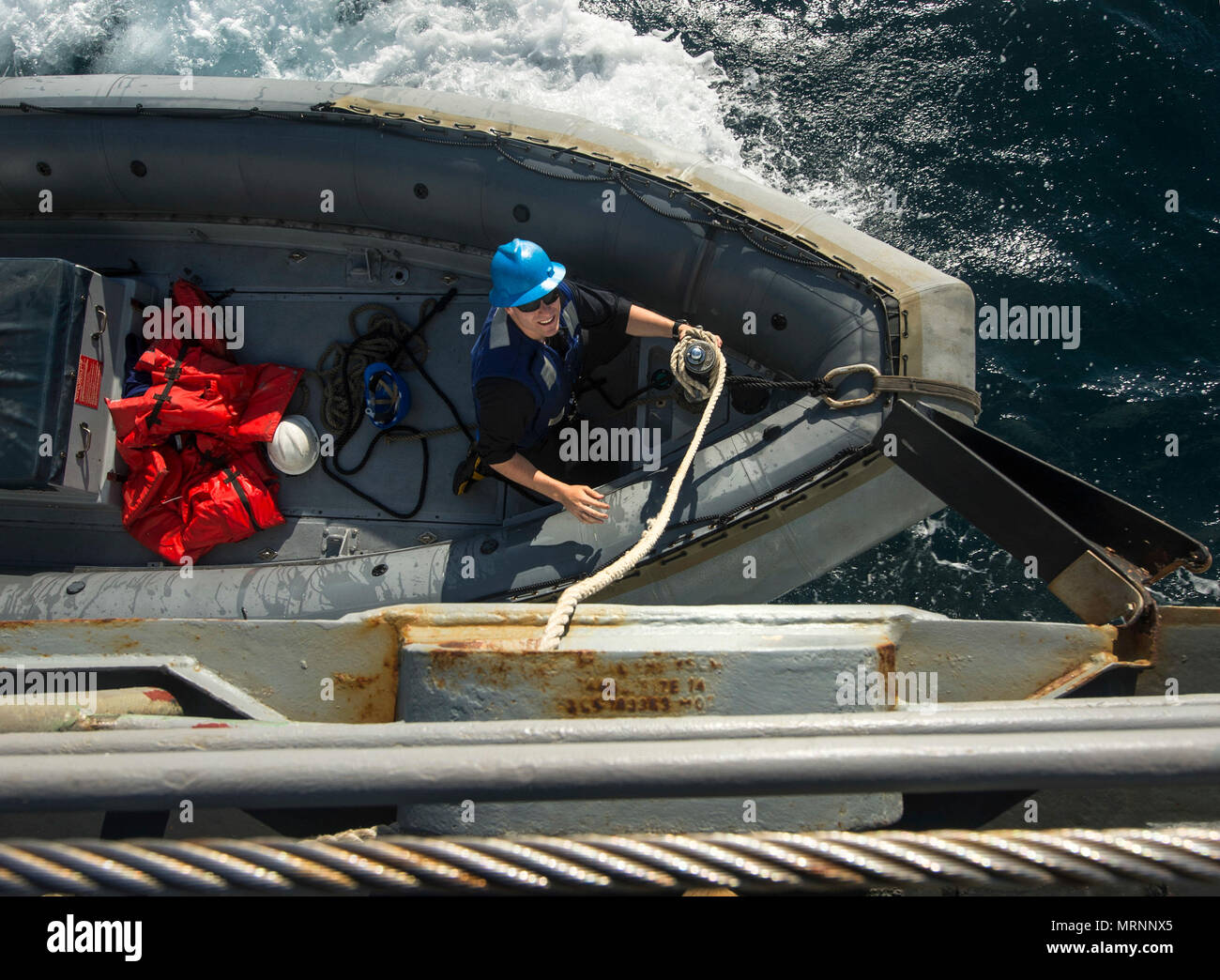 ARABIAN GULF (June 20, 2017) Engineman 3rd Class Joshua Hohn, assigned to the coastal patrol ship USS Firebolt (PC 10), works to secure a line on a rigid-hull inflatable boat as it pulls alongside the guided-missile cruiser USS Vella Gulf (CG 72for a personnel transfer during Exercise Spartan Kopis 17.  Exercise Spartan Kopis is a Task Force (TF) 55-led exercise between the U.S. Navy and U.S. Coast Guard in order to increase tactical proficiency, broaden levels of cooperation, enhance mutual capability and support long-term security and stability in the region. Vella Gulf is deployed to the U. Stock Photo