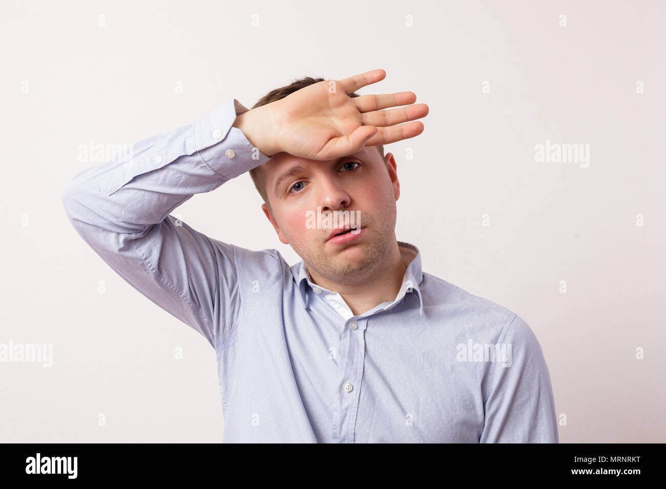 Tired caucasian young man in depression hold his head with hand. Stock Photo