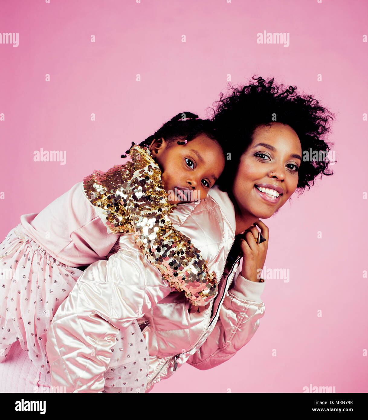 young pretty african-american mother with little cute daughter hugging,  happy smiling on pink background, lifestyle modern people concept close up  Stock Photo - Alamy
