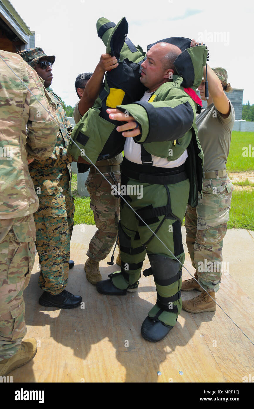 Lt. Stephen Ingargiola, assigned to the St. Bernard Sheriff Department, with the help of U.S. Soldiers, assigned to 705th EOD Company, 63rd EOD Battalion, 52nd EOD Group, 20th CBRNE Command, puts on the EOD-8 Bomb Suit during Raven’s Challenge 2017 at Camp Shelby, Miss., June 27, 2017. Raven’s Challenge is an annual training event that provides Explosive Ordnance Disposal personnel and Public Safety Bomb Squads of both military and government agencies interoperability in a realistic domestic tactical environment. (U.S. Army photo by Sgt. Ashley Marble, 55th Signal Company) Stock Photo