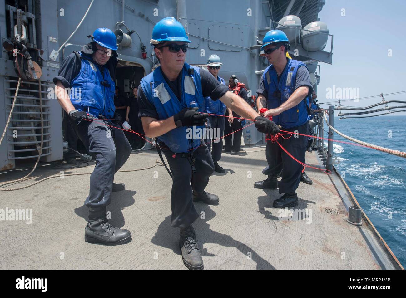 Seaman John Vanetten and Seaman Dowson Roth, assigned to the guided-missile cruiser USS Vella Gulf (CG 72), heave a messenger line during a replenishment-at-sea during Exercise Spartan Kopis 17, June 19. Exercise Spartan Kopis is a TF-55-led exercise between the U.S. Navy and U.S. Coast Guard in order to increase tactical proficiency, broaden levels of cooperation, enhance mutual capability and support long-term security and stability in the region. Vella Gulf is deployed with the U.S. 5th Fleet area of operations to reassure allies and partners, and preserve the freedom of navigation and the  Stock Photo