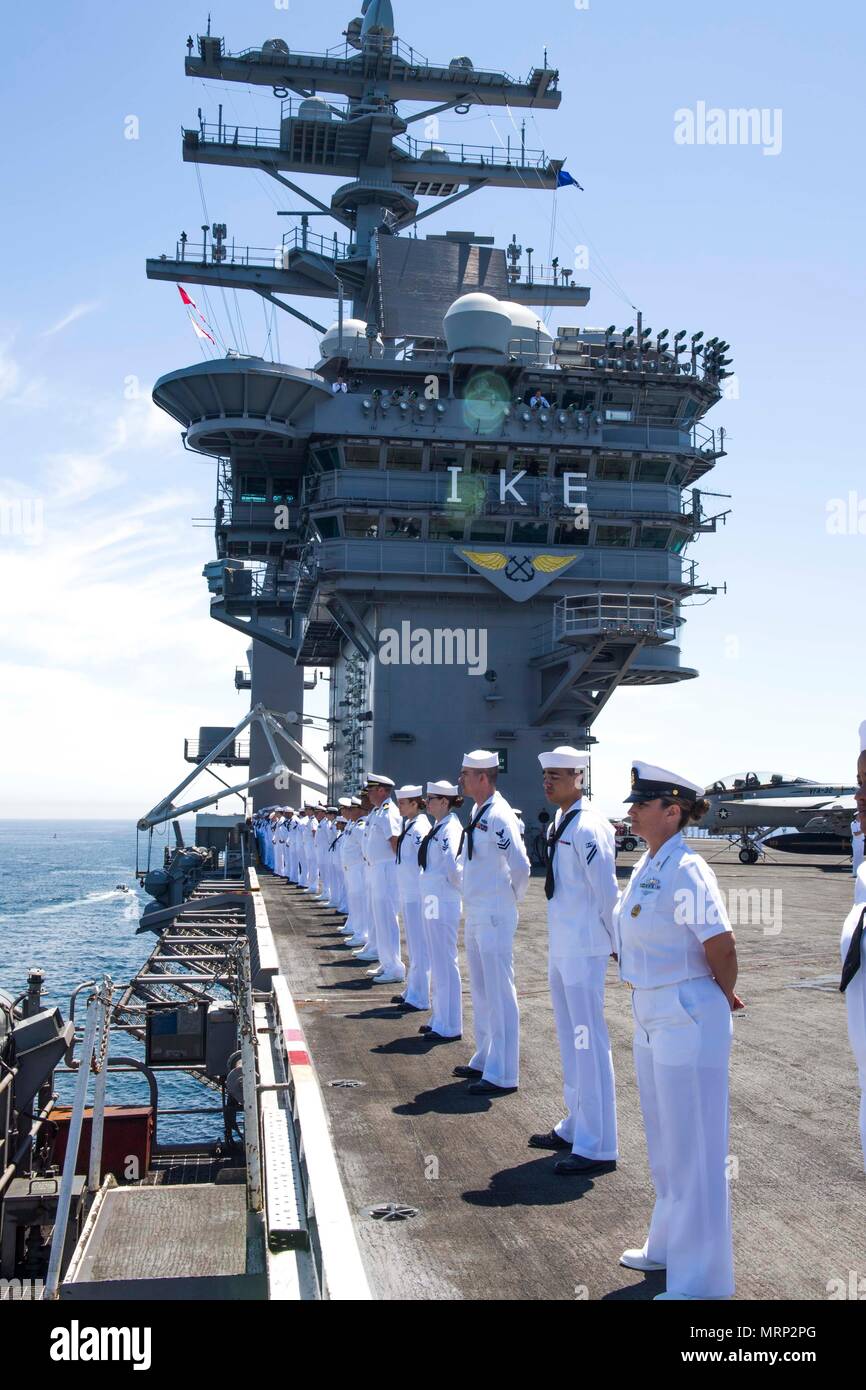 Sailors man the rails on the flight deck aboard the aircraft carrier