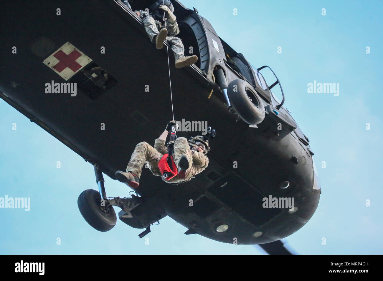 U.S. Air National Guard Senior Airman Michael Curley descends from a UH-60 Black Hawk helicopter during joint training for New Jersey Task Force One at Joint Base McGuire-Dix-Lakehurst, N.J., June 28, 2017. The primary mission of New Jersey Task Force One is to provide advanced technical search and rescue capabilities to victims trapped or entombed in structurally collapsed buildings. Task Force One is made up of New Jersey National Guard Soldiers and Airmen, as well as civilians. (U.S. Air National Guard photo by Master Sgt. Matt Hecht/Released) Stock Photo
