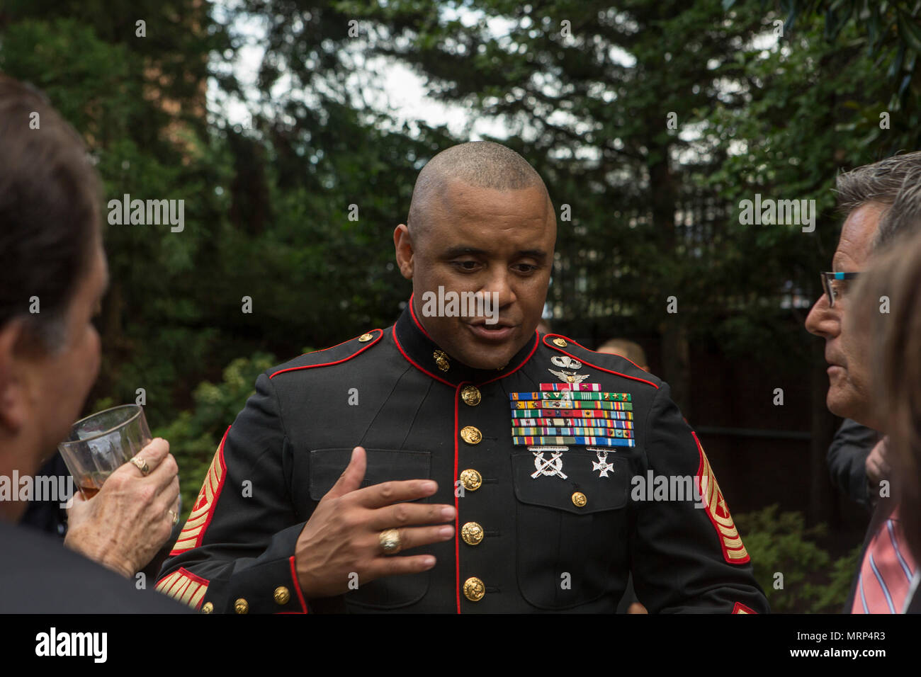 U.S. Marine Corps Sgt. Maj. Edward D. Parsons, sergeant major of Headquarters and Service Battalion, speaks with guests during a reception before an evening parade at Marine Barracks Washington, Washington D.C. June 23, 2017. Evening parades are held as a means of honoring senior officials distinguished citizens and supporters of the Marine Corps. (U.S. Marine Corps photo by Lance Cpl. Stephon L. McRae) Stock Photo