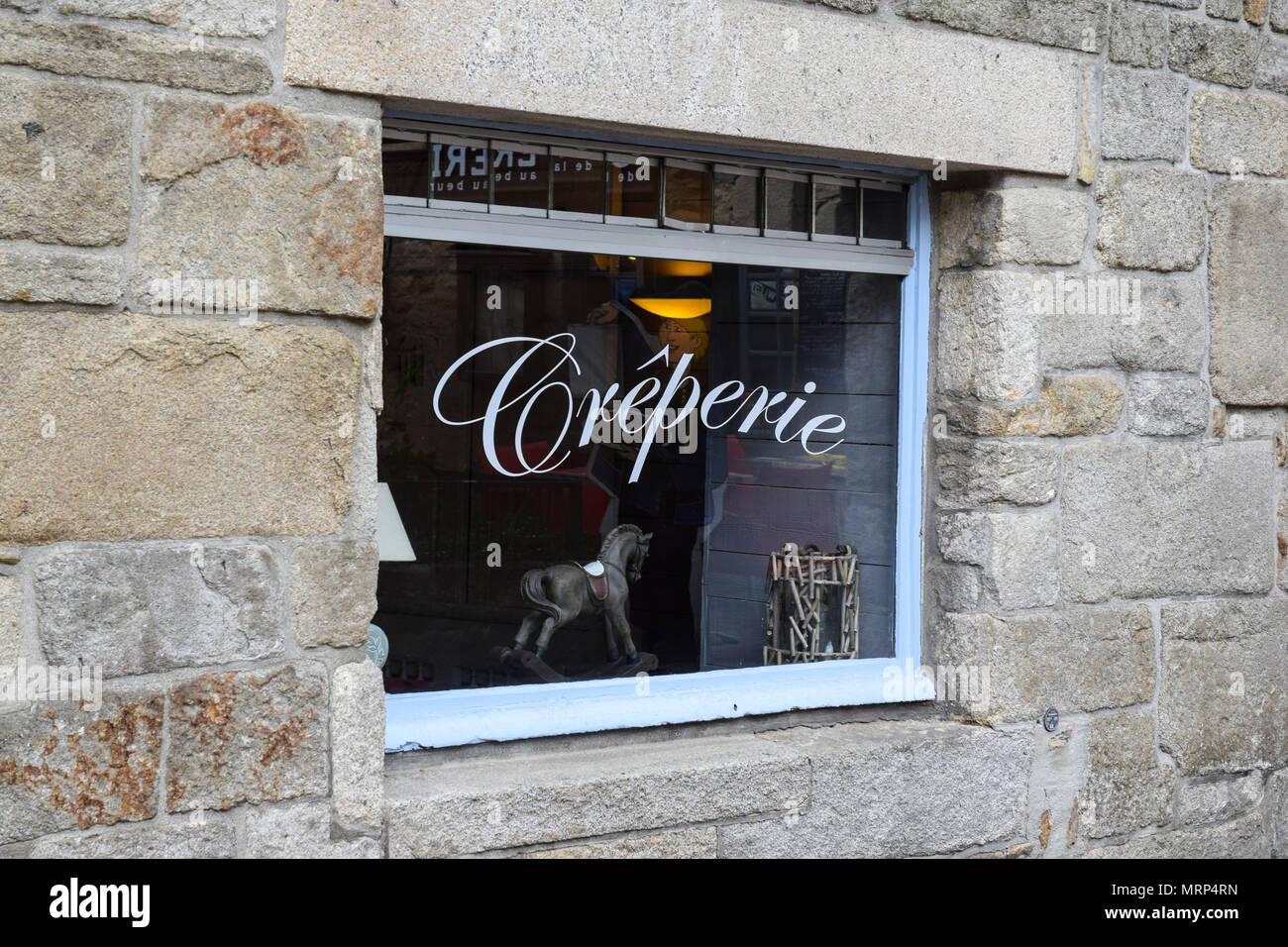 A creperie window in a historic stone building in Brittany, France. Stock Photo