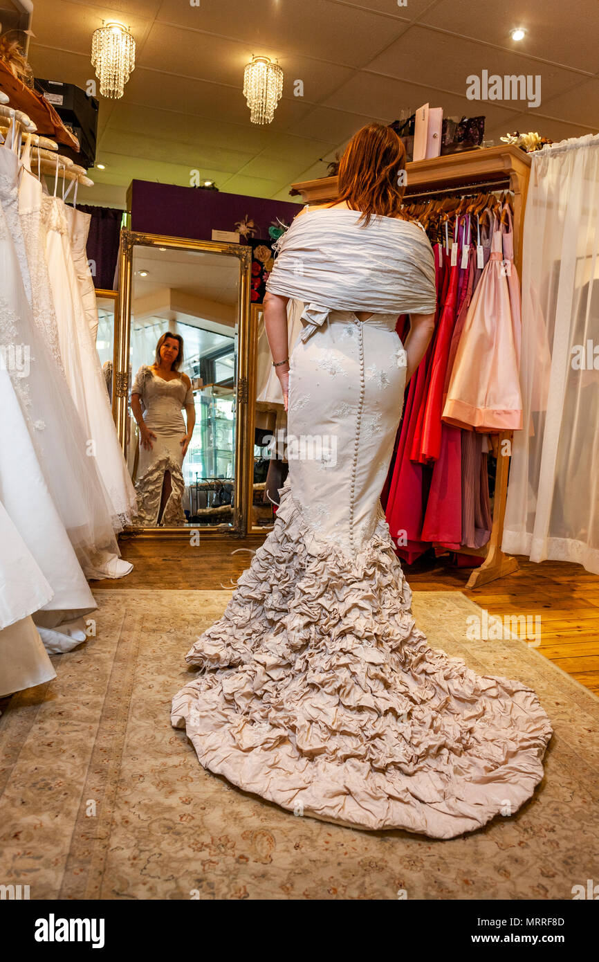 Wedding dress fitting. A bride tries on her dress for the first time while a seamstress makes adjustments Stock Photo Alamy