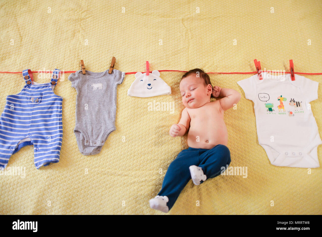 Little baby hanging with clothes on rope Stock Photo - Alamy