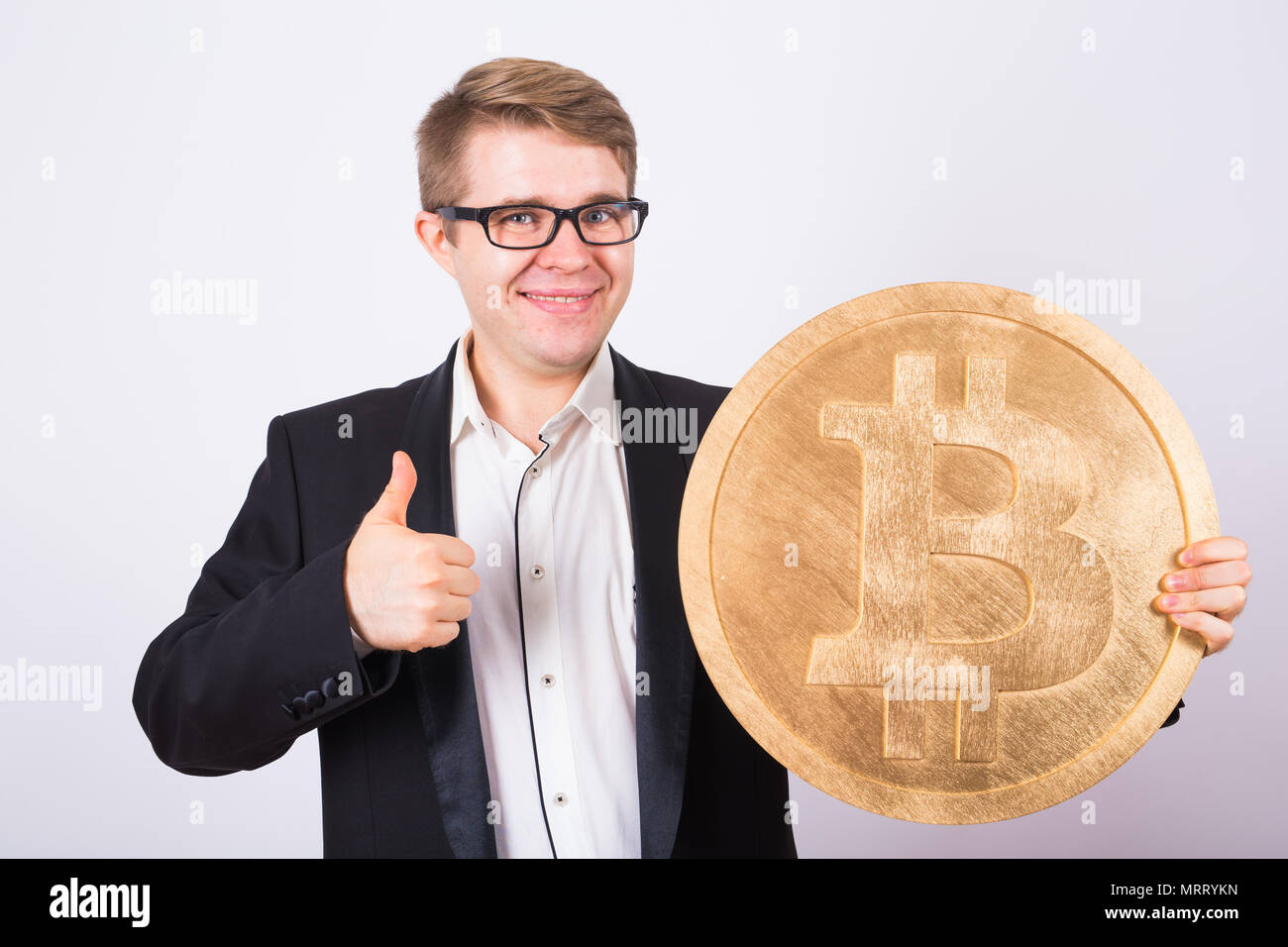 happy man holding big bitcoin and showing thumbs up Stock Photo - Alamy