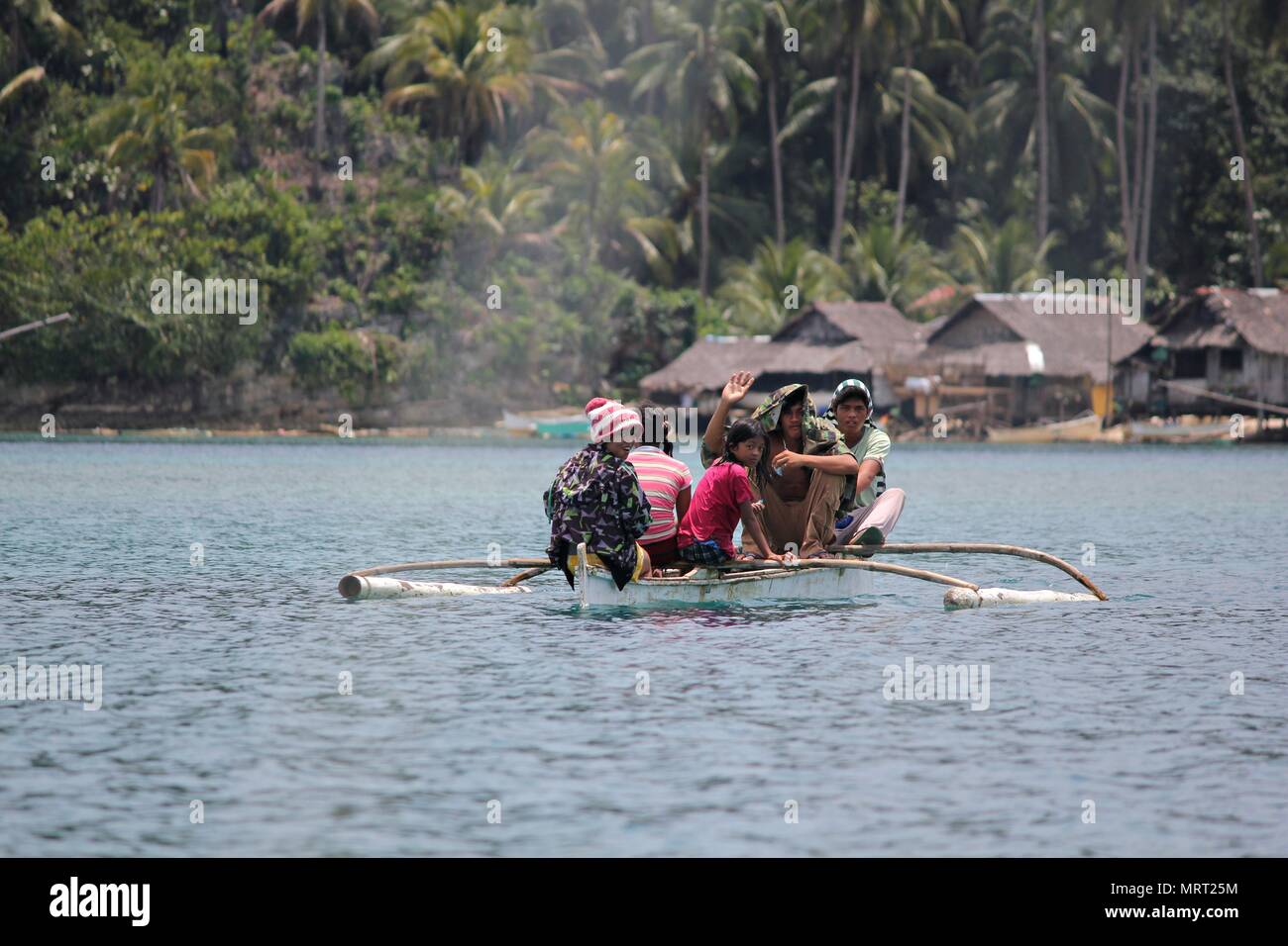 Passengers of a small boat approach the village of Libtong Cove in Cantilan, Surigao del Sur. Stock Photo