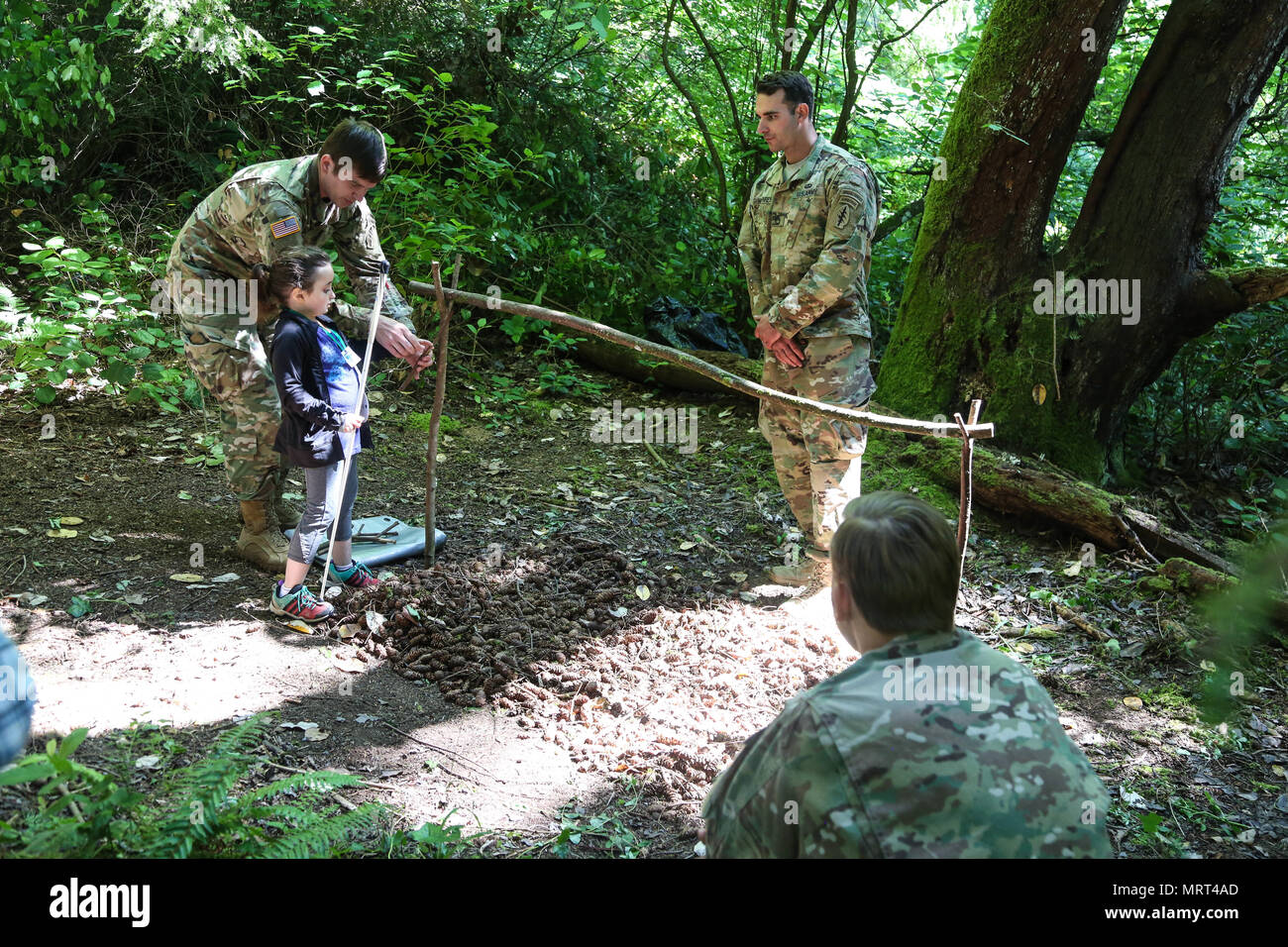 Green Berets assigned to 1st Special Forces Group (Airborne) teach children from Saint Jude’s Children's Hospital survival skills on June 30th at Vashon Island, WA. The Soldiers showed the children how to survive in the wilderness by teaching them how to build shelters, start fires, and administer first aid. Stock Photo