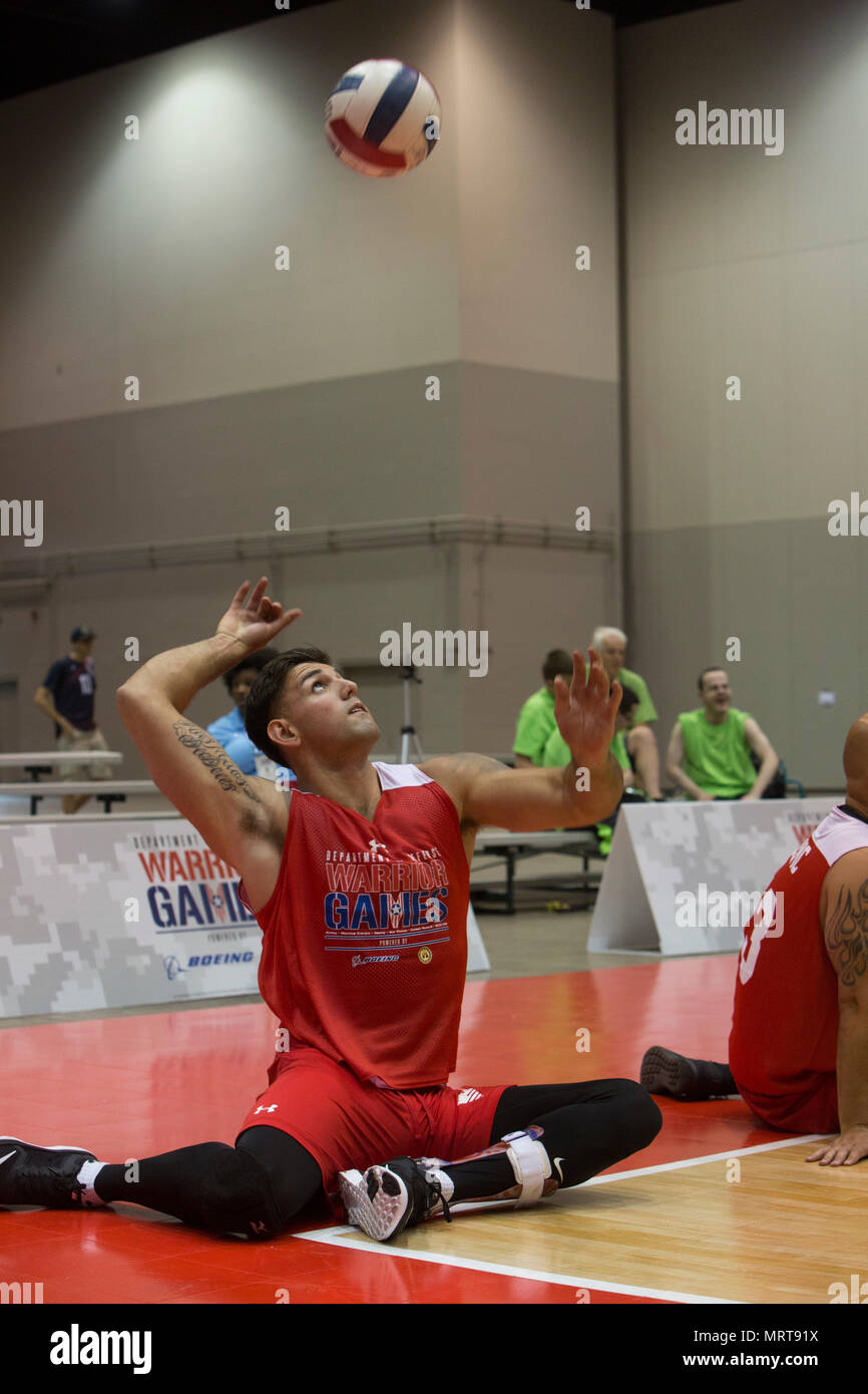 U.S. Marine Corps Lance Cpl. Michael Sousa Docarmo serves the volleyball over the net during a 2017 DoD Warrior Games sitting volleyball match at McCormick Place in Chicago, June 30, 2017. Sousa Docarmo, a native of Millbrook, N.Y., is a member of Team Marine Corps. The Warrior Games is an adaptive sports competition for wounded, ill and injured service members and veterans. (U.S. Marine Corps photo by Lance Cpl. Nadia J. Stark) Stock Photo