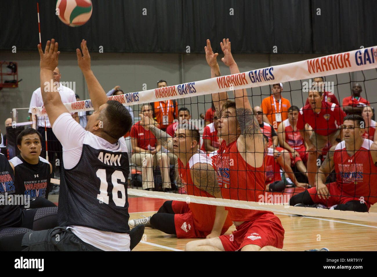 U.S. Marine Corps Sgt. Tyler Denney, left, and Cpl. Dakota Boyer, right, work together to make a hit against the 2017 DoD Warrior Games Team Army sitting volleyball team at McCormick Place in Chicago, June 30, 2017. The Warrior Games is an adaptive sports competition for wounded, ill and injured service members and veterans. (U.S. Marine Corps photo by Lance Cpl. Nadia J. Stark) Stock Photo