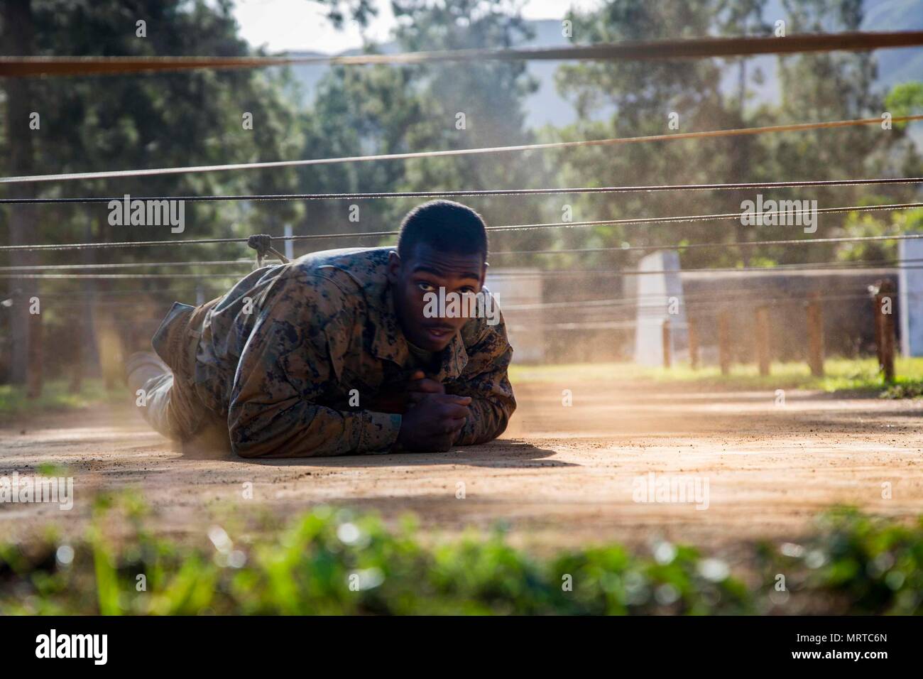 U.S. Marine Corps Lance Cpl. Tyreke Wiggins, an infantryman with Task Force Koa Moana 17, low crawls under an obstacle as a part of the North Atlantic Treaty Organization  obstacle course at Plum, New Caledonia, June 30, 2017. Koa Moana 17 is designed to improve interoperability with our partners, enhance military-to-military relations, and expose the Marine Corps forces to different types of terrain for familiarity in the event of a natural disaster in the region.   (U.S. Marine Corps photo by MCIPAC Combat Camera Lance Cpl. Juan C. Bustos) Stock Photo