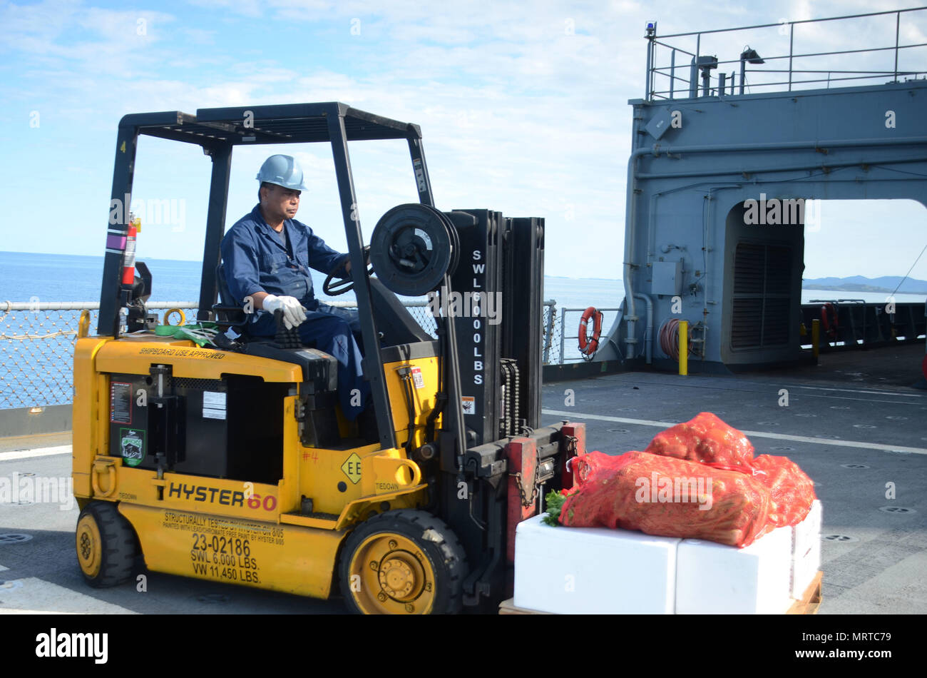 170706-N-WJ640-022 NOUMEA, New Caledonia (July 06, 2017) Nito Catunao, Boatswains Mate onboard USNS Sacagawea (T-AKE 2), operates a forklift during stores onload off shore Noumea, New Caledonia in support of Koa Moana 17, July 6. Koa Moana 17 is designed to improve theater security, and conduct law enforcement and infantry training in the Pacific region in order to enhance interoperability with partner nations. (U.S. Navy photo by Mass Communication Specialist 3rd Class Madailein Abbott) Stock Photo