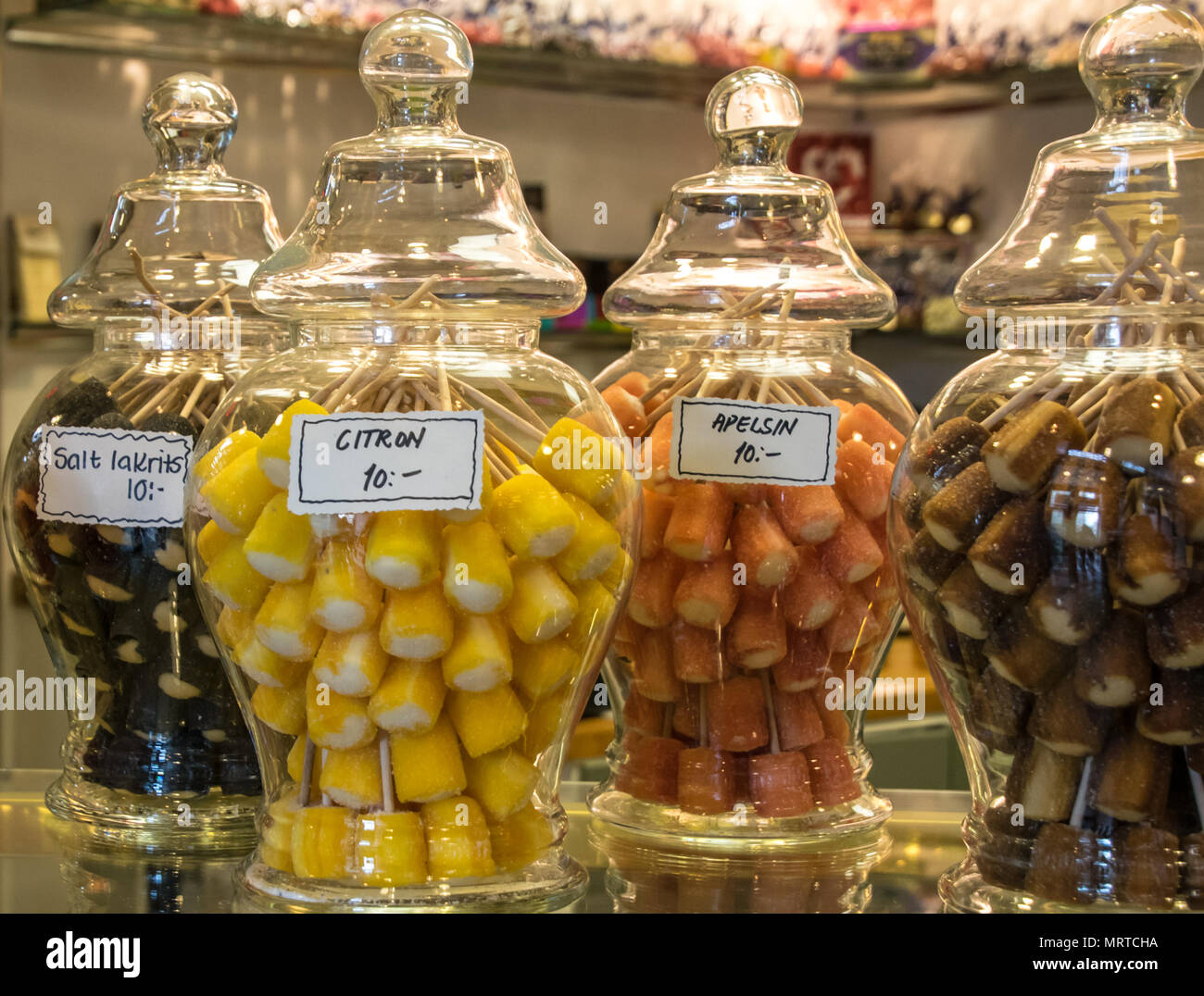 colorful candies in large glass jars on a counter at a Swedidh candy shop Stock Photo