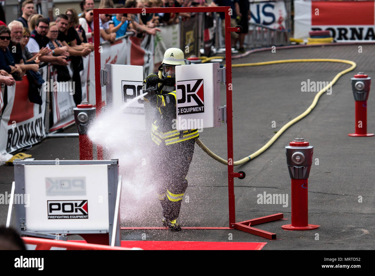 A german firefighter uses a hose to knock down a target during the 4th  annual Mosel Firefighter Combat Challenge in Ediger-Eller, Germany, June  30, 2017. Competitors from 12 countries raced head-to-head as